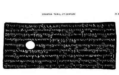 Facsimile of nine lines of rounded Grantha-Tamil letters, white on black, with a round ring-hole near the middle of the plate.