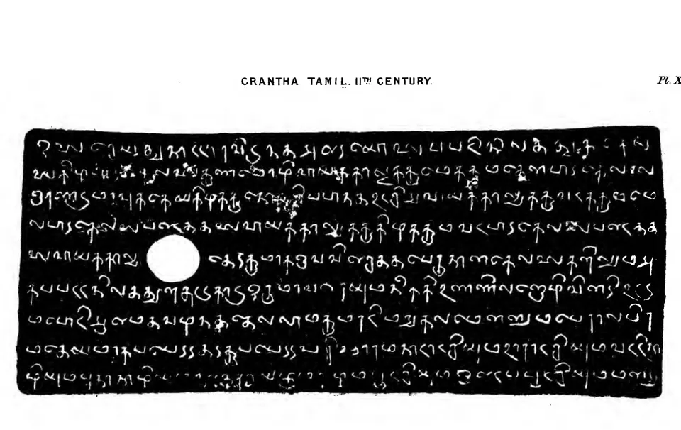 Facsimile of nine lines of rounded Grantha-Tamil letters, white on black, with a round ring-hole near the middle of the plate.