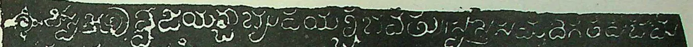 Detail of an ink impression: one line of white Telugu-Kannada letters on a black ground, beginning with an ornamental sign.