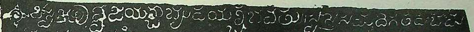 Detail of an ink impression: one line of white Telugu-Kannada letters on a black ground, beginning with an ornamental sign.
