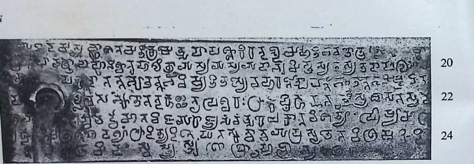Photograph of one inscribed copper plate on its ring, six lines of Pallava-Grantha script with line numbers 20 to 24.