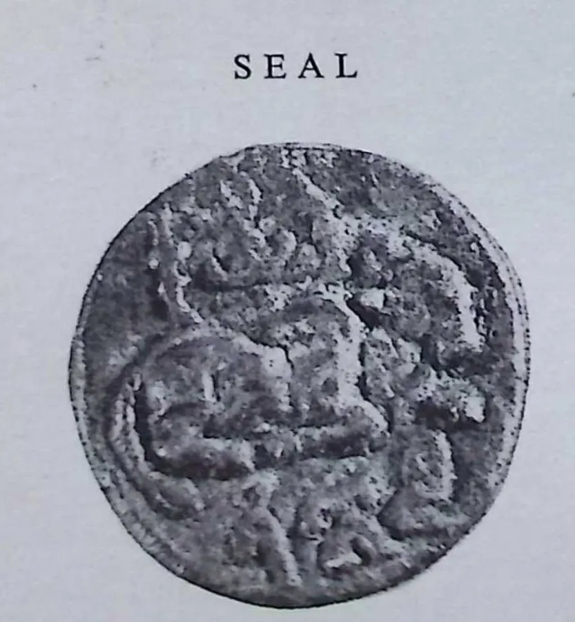 Photograph of a round bronze seal, worn, with a raised couchant animal across the middle, under the printed word "SEAL".