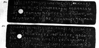 Two long copper-plate facsimiles, white letters on black, each with a round ring hole and four lines of southern (Pallava) script, labelled III a and III b.