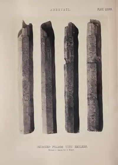 Photograph of four tall square pillars carved with emblems.