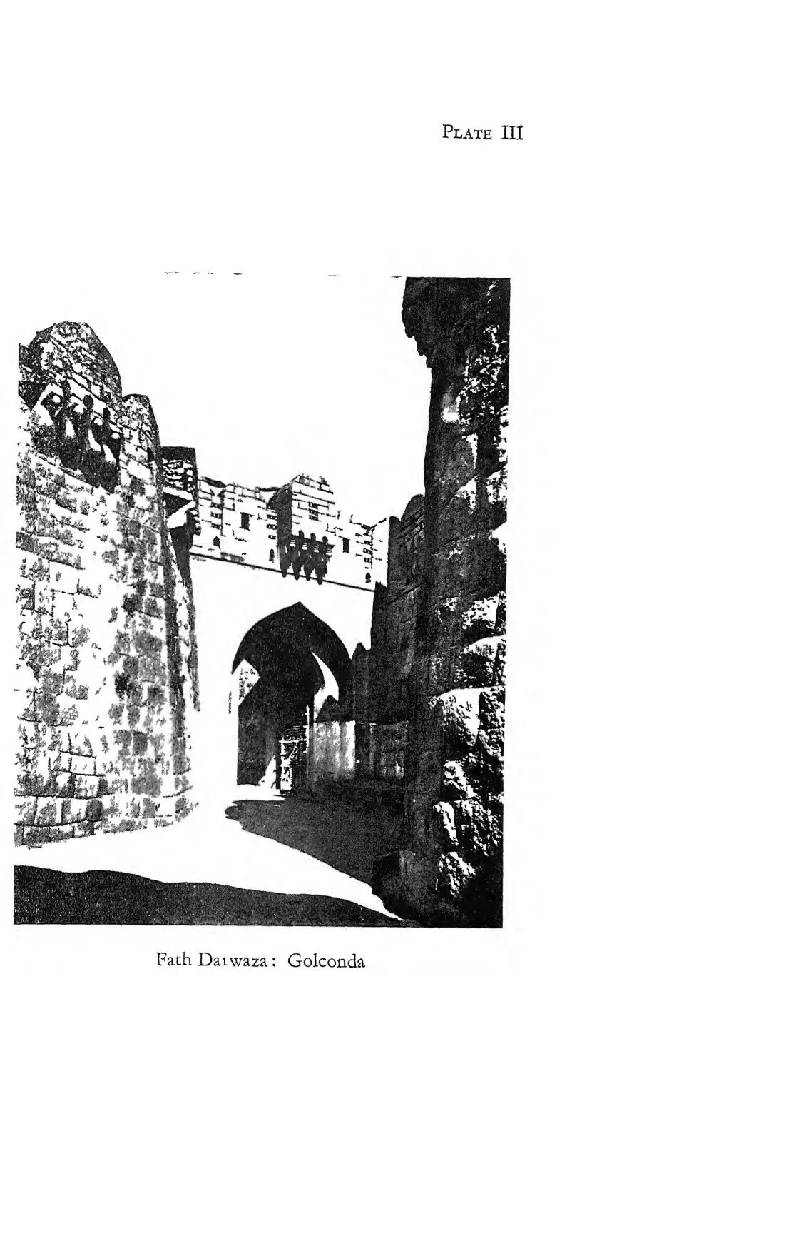 Photograph of the arched Fath Darwaza gateway between high stone walls with battlements.