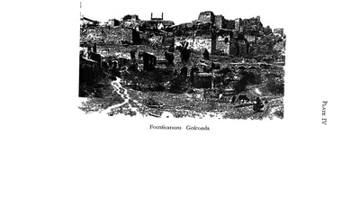 Photograph of ruined fortification walls and buildings climbing the rocky hill at Golconda.
