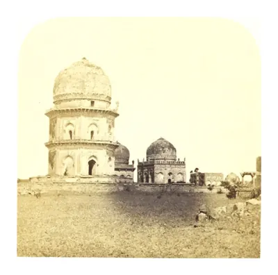 Old photograph of a tall domed tomb on a terrace with smaller domes beside it on open ground.