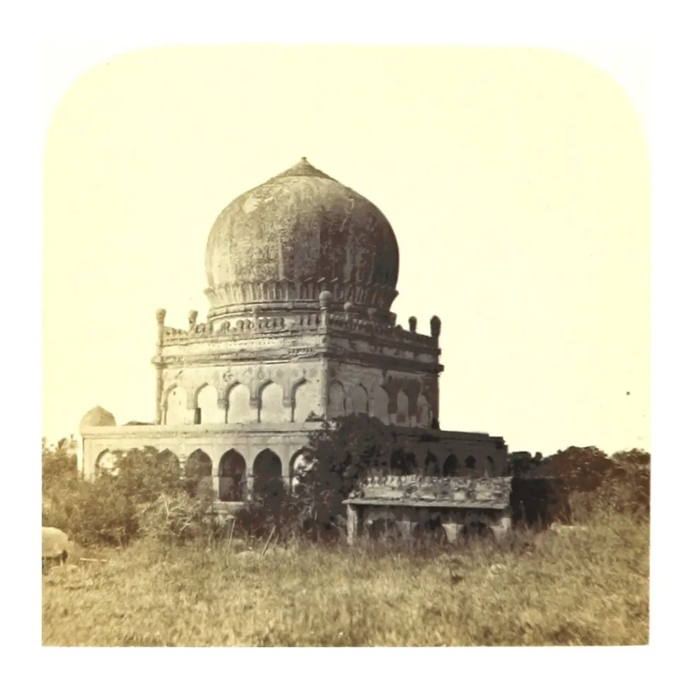 Old photograph of a domed tomb on an arcaded square base standing in grass.