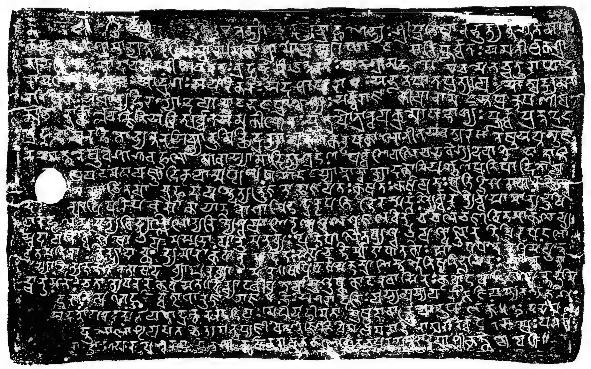 Ink impression of one side of an inscribed copper plate, Sanskrit in Nagari letters, lines 54–73, with a ring hole; parts of the plate surface print solid black.