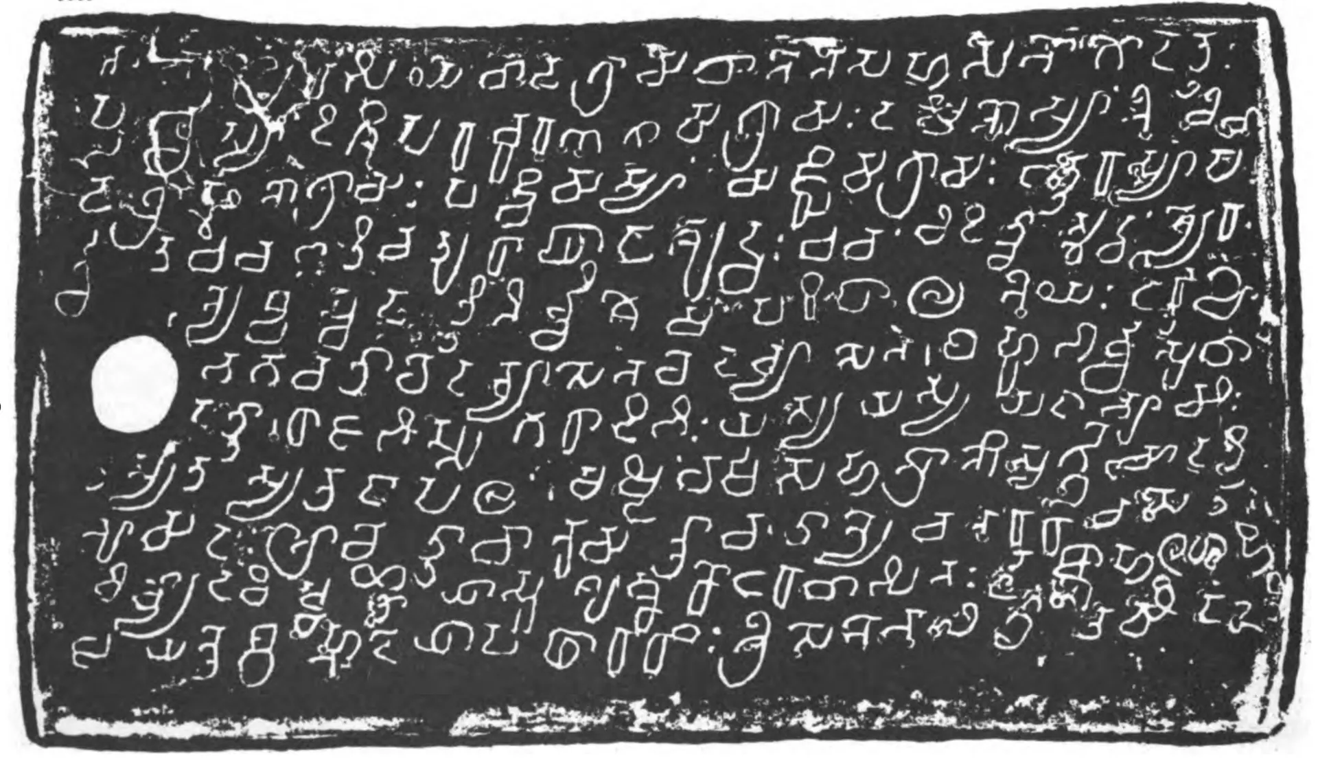 Ink impression of one side of an inscribed copper plate with thickened rims, white Sanskrit letters in the southern alphabet on a dark ground, lines 35–44, approximately, with a ring hole at the left.