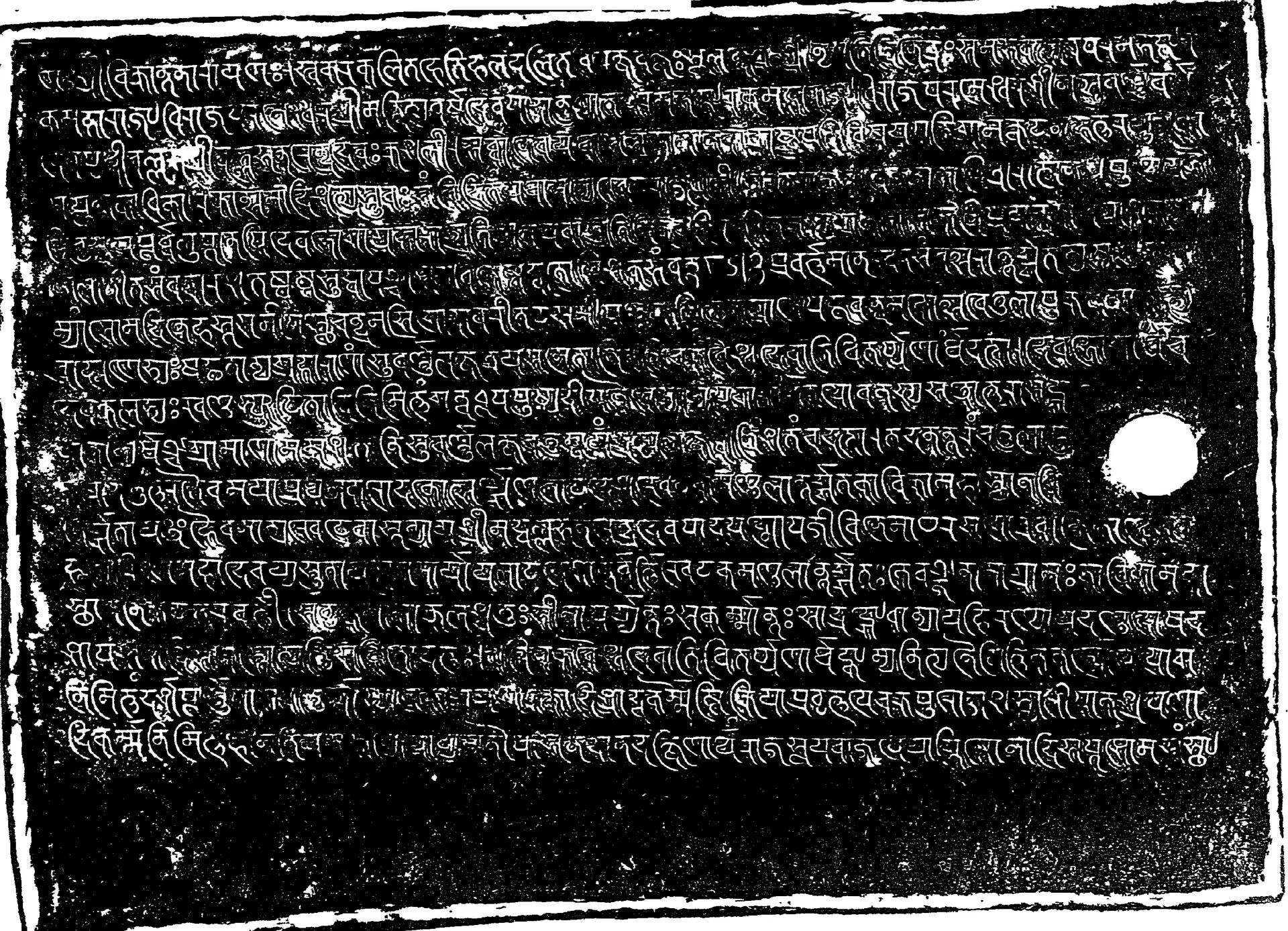 Facsimile of one side of an inscribed copper plate, white Sanskrit letters in Nagari on a black ground in about twenty lines, with a ring hole.