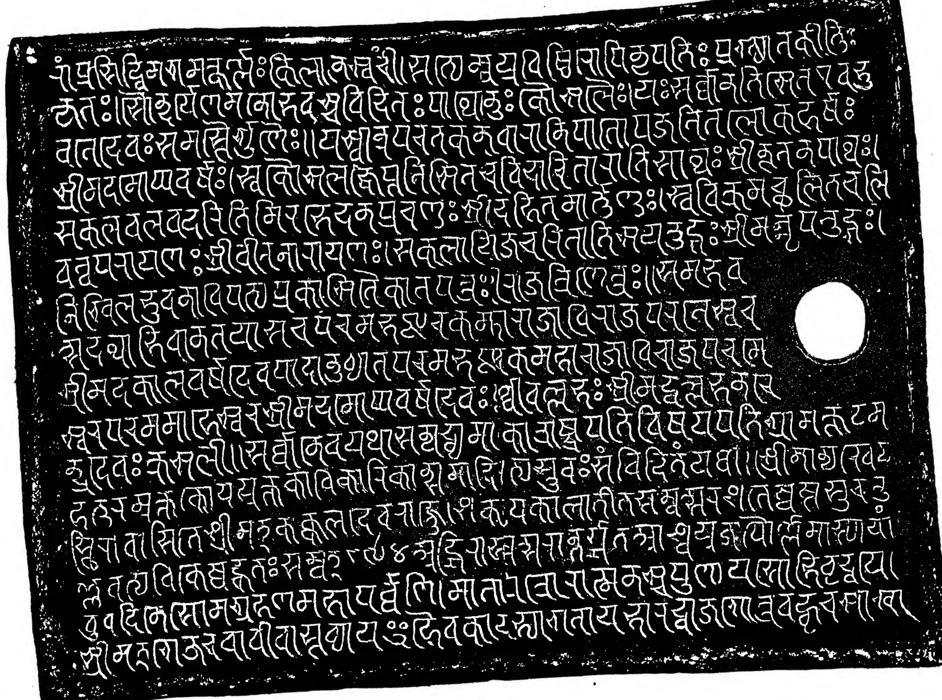 Facsimile of an inscribed copper plate with thickened rims, white Sanskrit letters in Nagari on a black ground, with a round ring hole.