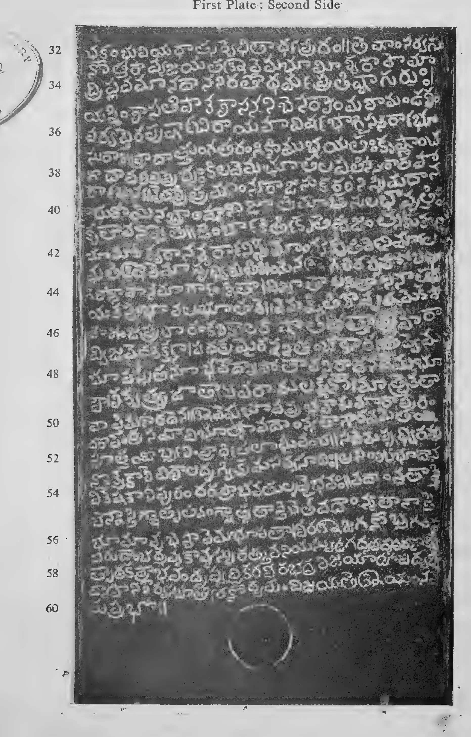 Photograph of one inscribed copper-plate face, upright and narrow, about thirty lines of light Telugu letters on the dark metal, with a raised rim and the ring hole at one end; line numbers printed in the margin.