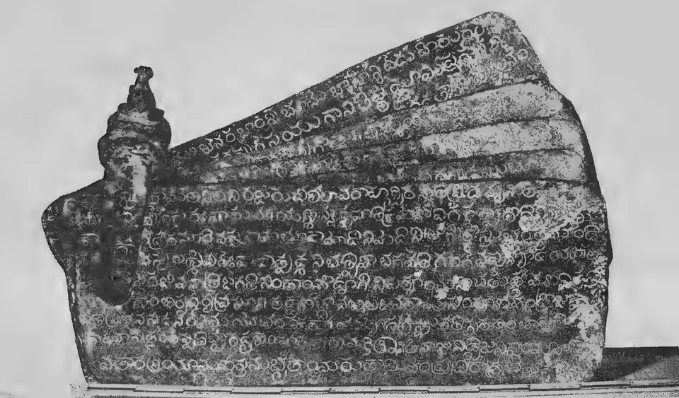 Photograph of five inscribed copper plates fanned out on their ring, the ring rising at the left into a seal topped by a small seated bull.