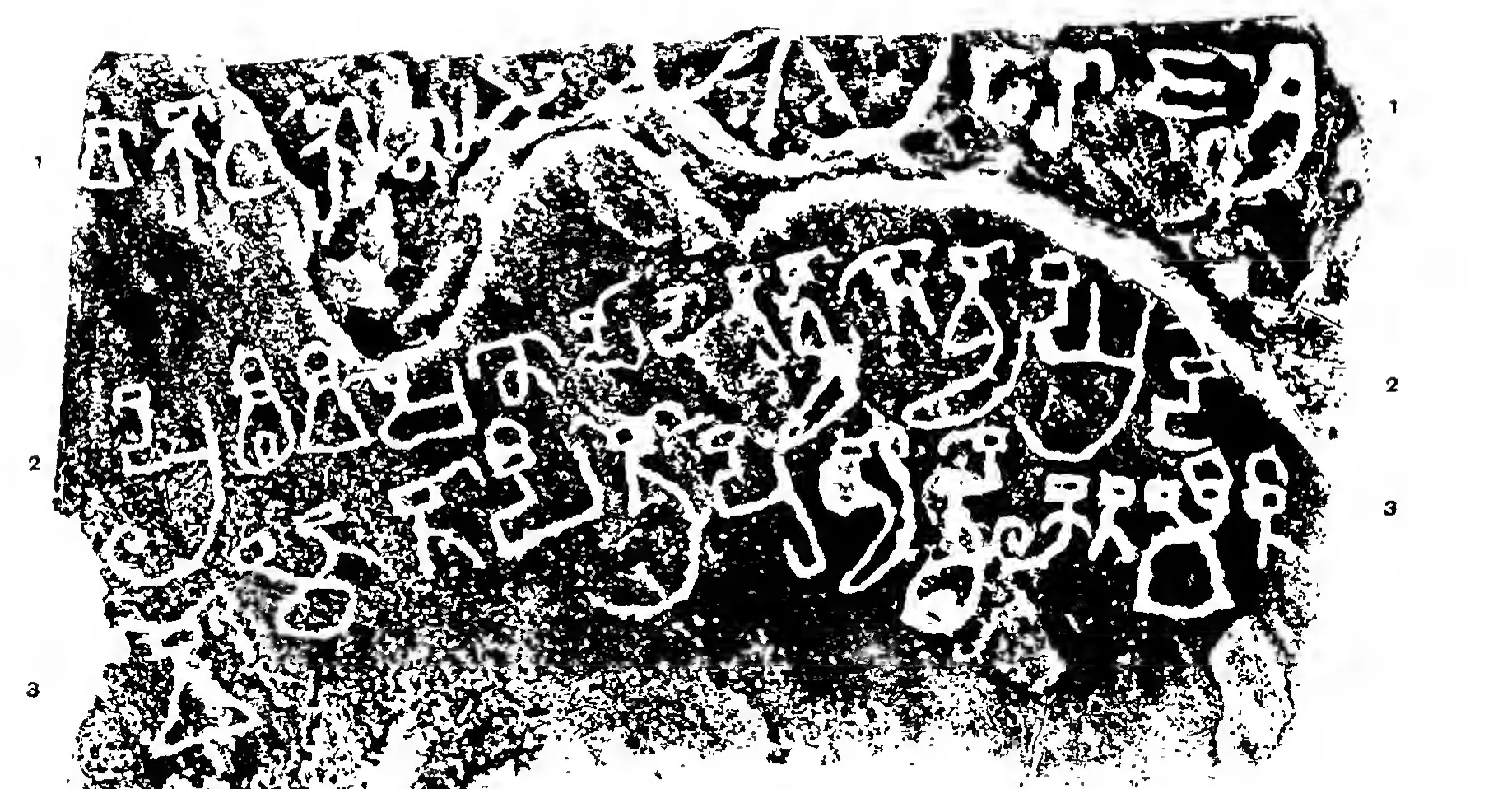 Black estampage of a stone slab with three lines of large old letters in white and part of a carved wheel at the top.