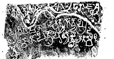Black estampage of a stone slab with three lines of large old letters in white and part of a carved wheel at the top.