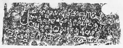 Ink impression of a wide, low inscribed band of a hero-stone with four lines of deeply cut early Telugu letters, white on black.