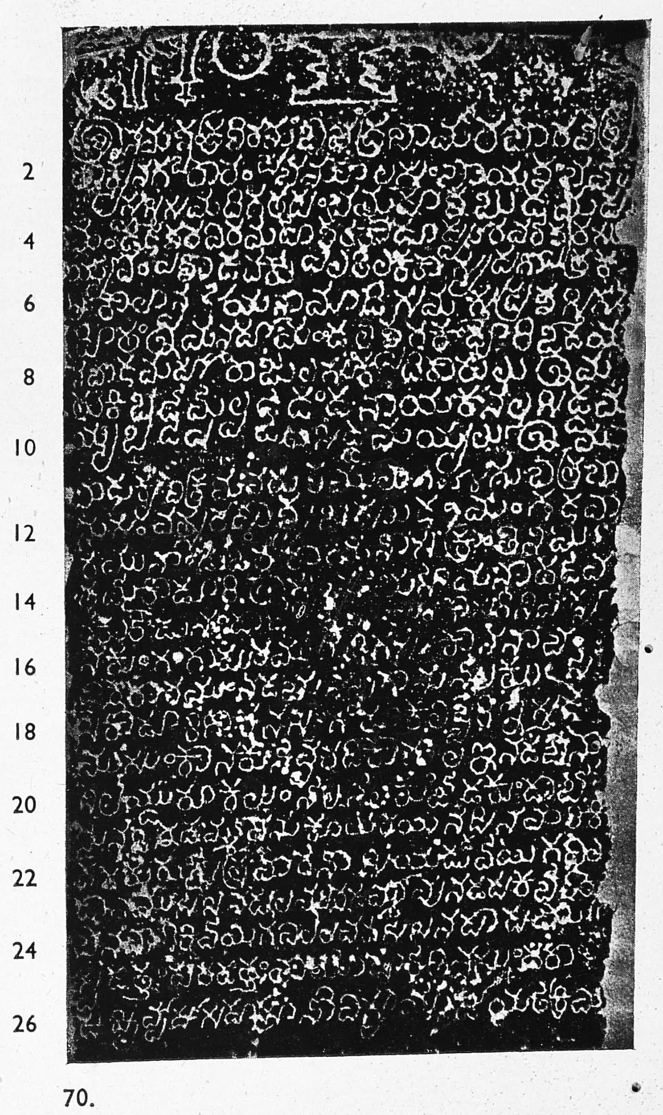 Ink impression of an inscribed stone slab, small white Telugu letters on black, twenty-seven numbered lines, with an emblem and large letters in the top line.