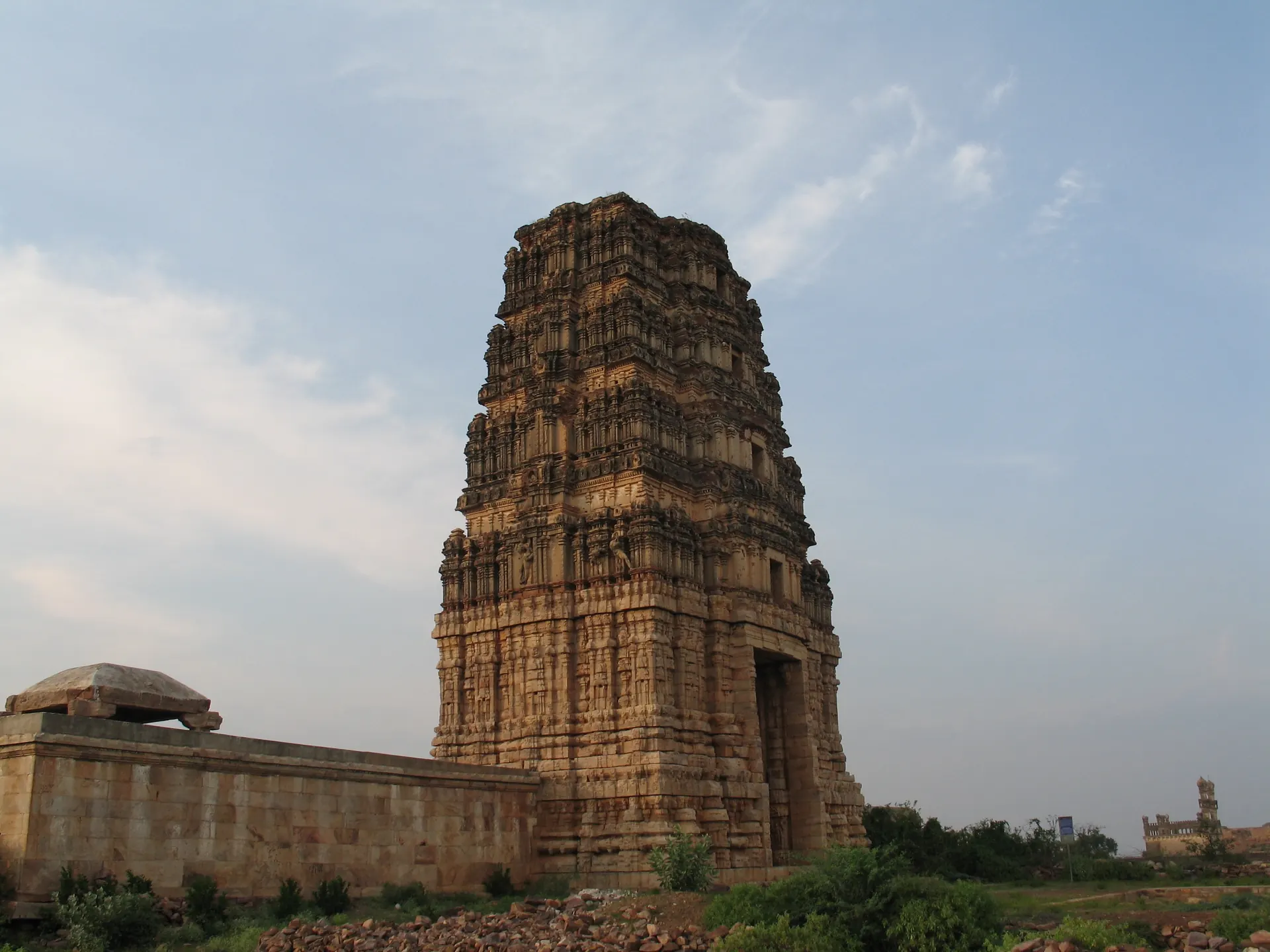 Colour photograph of a tall stone and brick gateway tower rising above the walls of a temple enclosure inside the Gandikota fort.