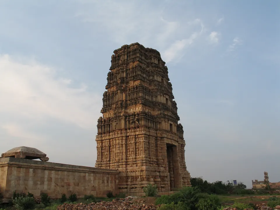 Colour photograph of a tall stone and brick gateway tower rising above the walls of a temple enclosure inside the Gandikota fort.