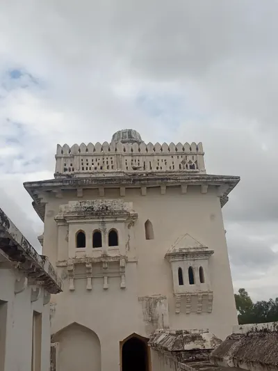 Colour photograph of a whitewashed two-storeyed palace building with arched windows and a crenellated square tower.