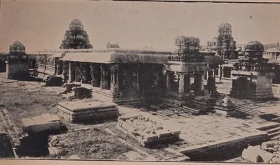 Photograph of the ruined courtyard of the Krishna temple at Hampi: a pillared hall and shrines with stepped towers, fallen stones in the foreground.